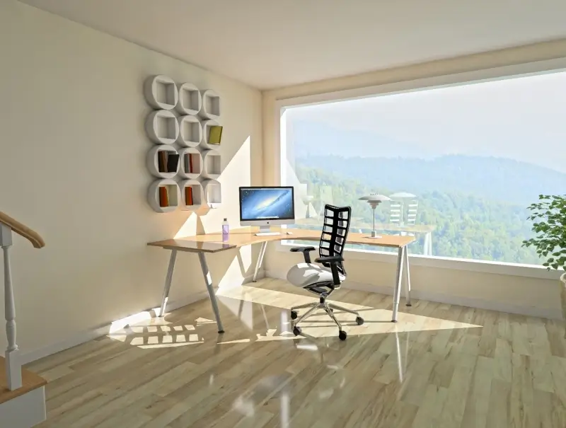 Un espace de travail avec un bureau d'ordinateur et une fenêtre.